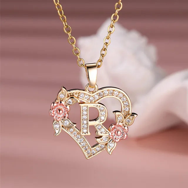 The letter R in a heart pendant necklace with rhinestones