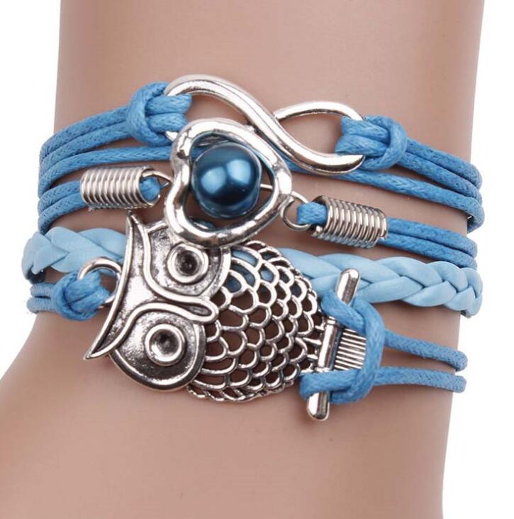 Blue Owl multilayer friendship type wider bracelet. has an eternity charm, owl and a heart & bead across 4 differing strands. The strand next to the owl is plain and plaited
