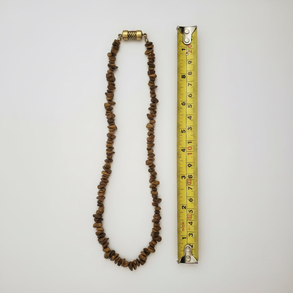 A Tigers eye stone chip necklace laid next to a yellow tape measure to show its length closed, with a white background. the clasp is like the first two images not as depicted in this image.  its opened full length is 40 cms
Image 4 = background removed, clasp altered ⚠️ — by Ai