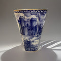 A blue and white illustrated ceramic Vase, Ringtons Tea Collectibles, Landmark Vase with blue architectural cityscape panels and gold trim, photographed on a light gray studio background with a cast shadow.