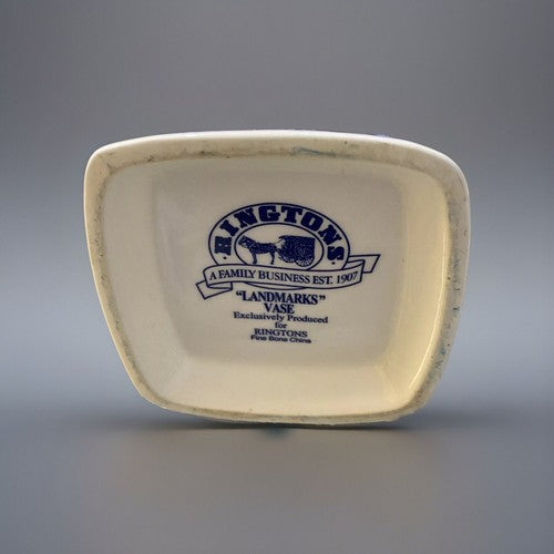 An off-white ceramic collectible vase with rounded corners, featuring a blue printed logo for 'Ringtons Landmarks' on the inside base, set against a neutral gray background. Sins of wear to the base edges but no chips seen