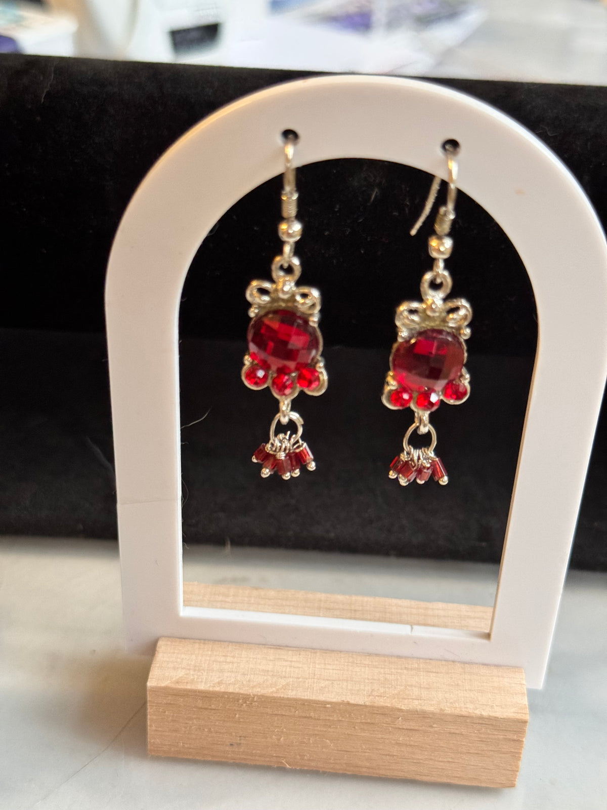 SIlver tone dangle earrings with a red main stone and 3 smaller underneath and then a jump ring with smaller oval red stones. very pretty.