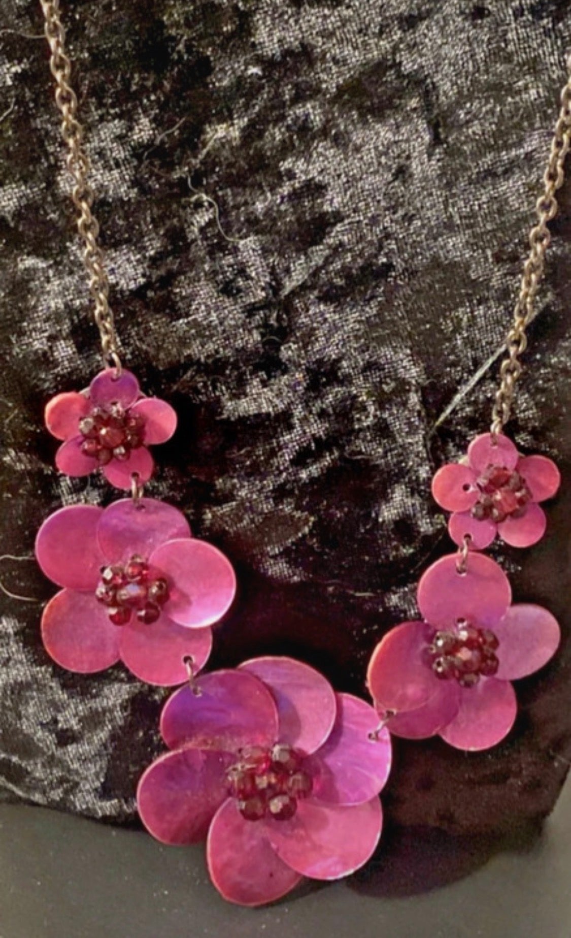 Deep Pink Shell flowers set on a silver tone chainSet on a black velvet bust.