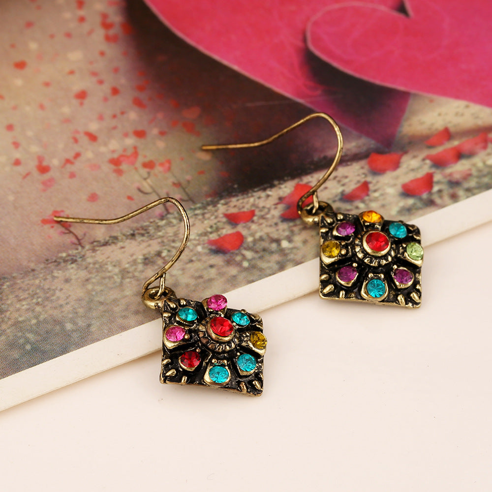 An Amazing boho design incorporating semi precious style stones n a geometric design with a white surface and small red petals and paper hearts