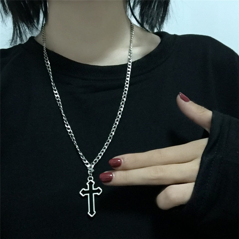 Gothic chain and cross with a curb stye mid chest length and a silver tone. the cross has a hollow center