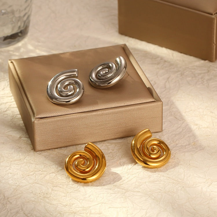 The golden & silver toned swirl earrings displayed together on a packaging box. ( The box is for display purposes.