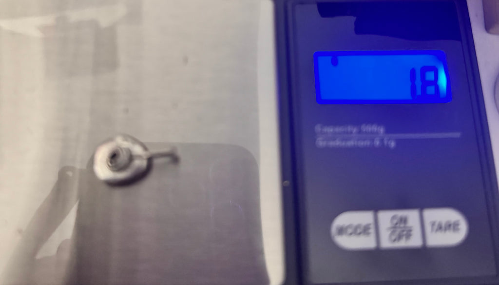 A close up fo the rose pendant on the scale showing 1.8 grams of silver