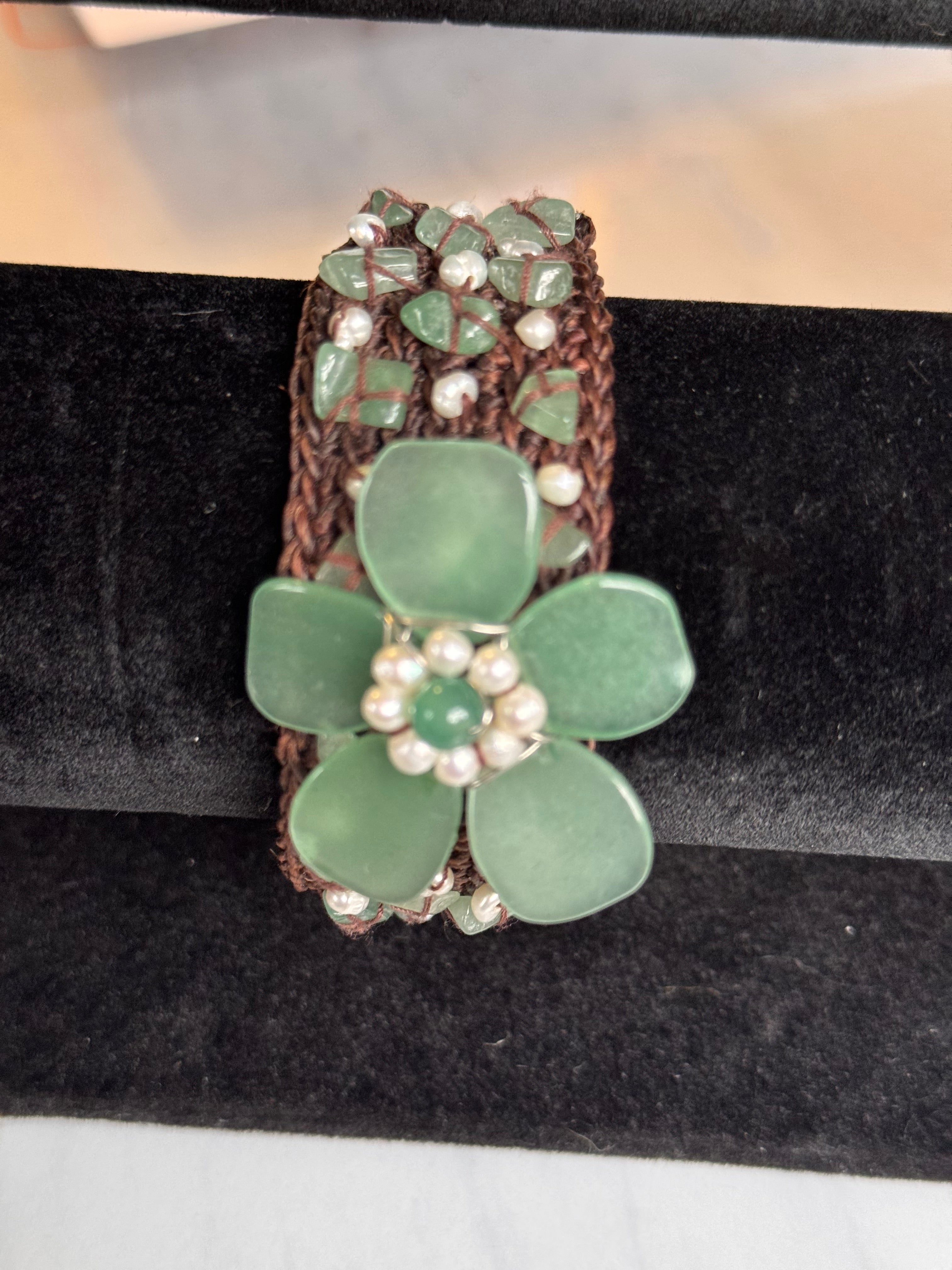 Close-up of large carved green jade flower on vintage woven bracelet