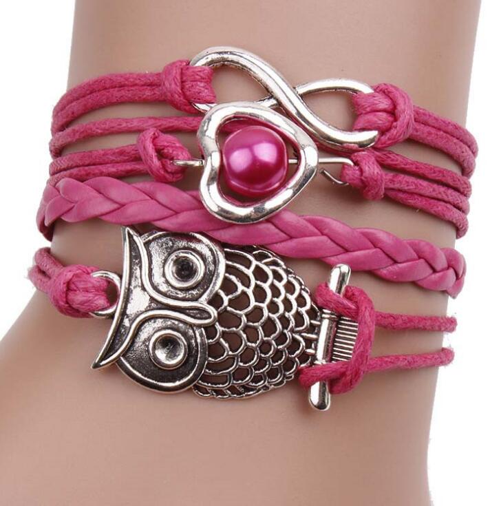 Pink Owl multilayer friendship type wider bracelet. has an eternity charm, owl and a heart & bead across 4 differing strands. The strand next to the owl is plain and plaited