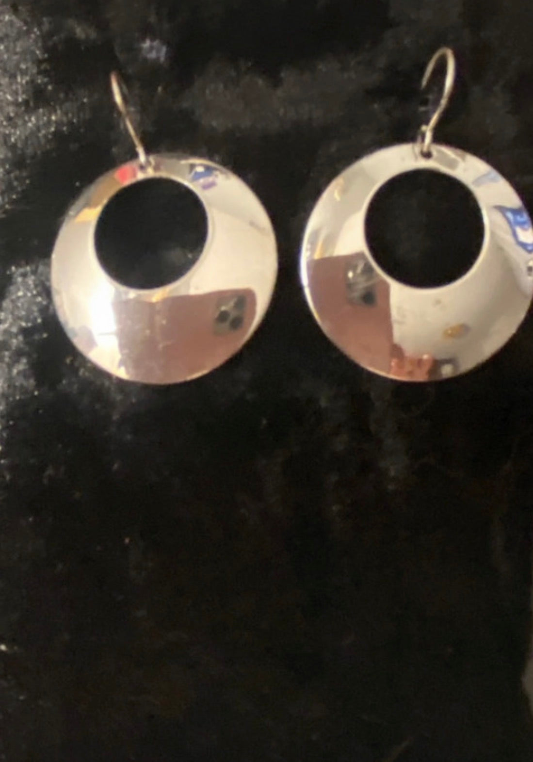 Silver plated Circle drop earrings on fish hooks. Have a centre round hole and the circle is wider at the bottom than the top. Stunning elegant drop earrings.