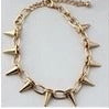 A gold-toned spiked chain necklace with sharp, pyramid-like studs, shown against a plain white background.
