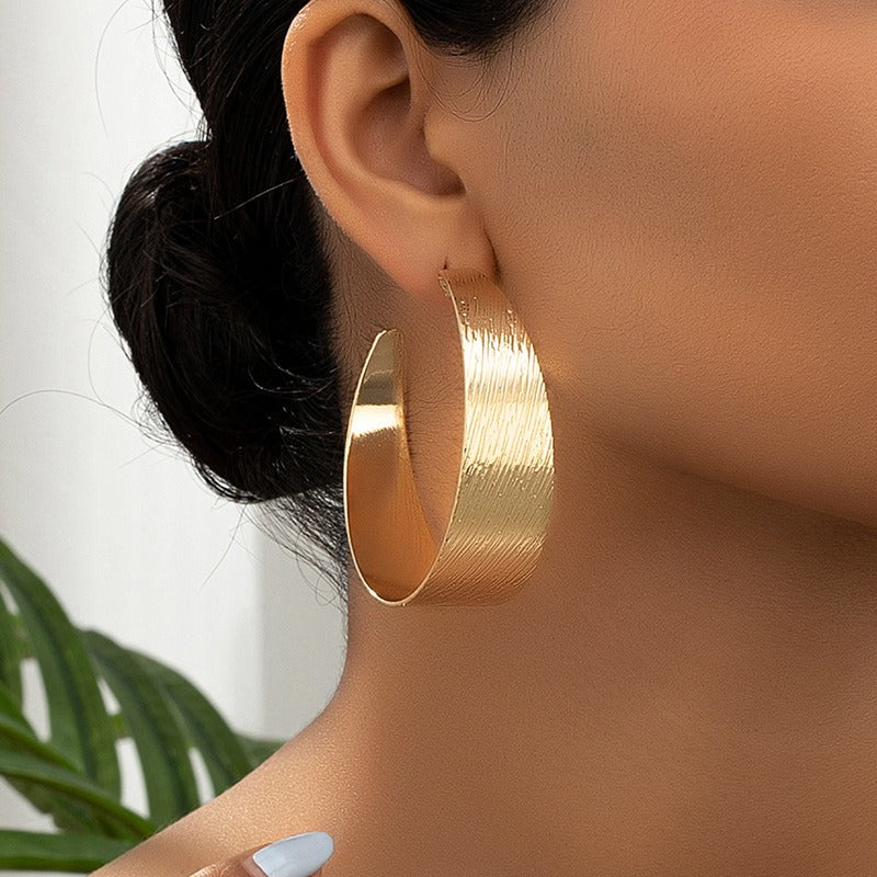 The earring in a persons ear. Very Nice Style of textured earrings. a Geometric textured style