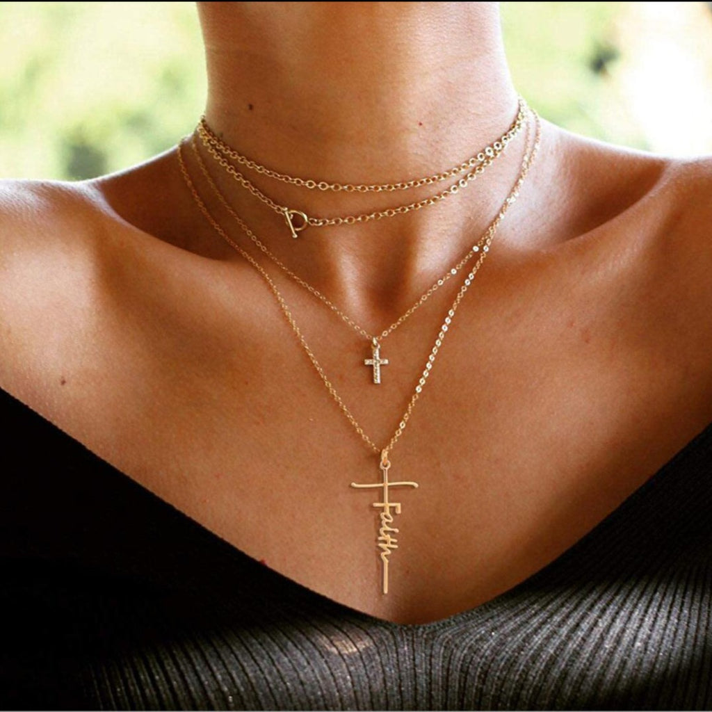 This image shows the Gold tone Faith Cross. Being worn by a lady as a layered necklace but this sale is for the cross and chain only