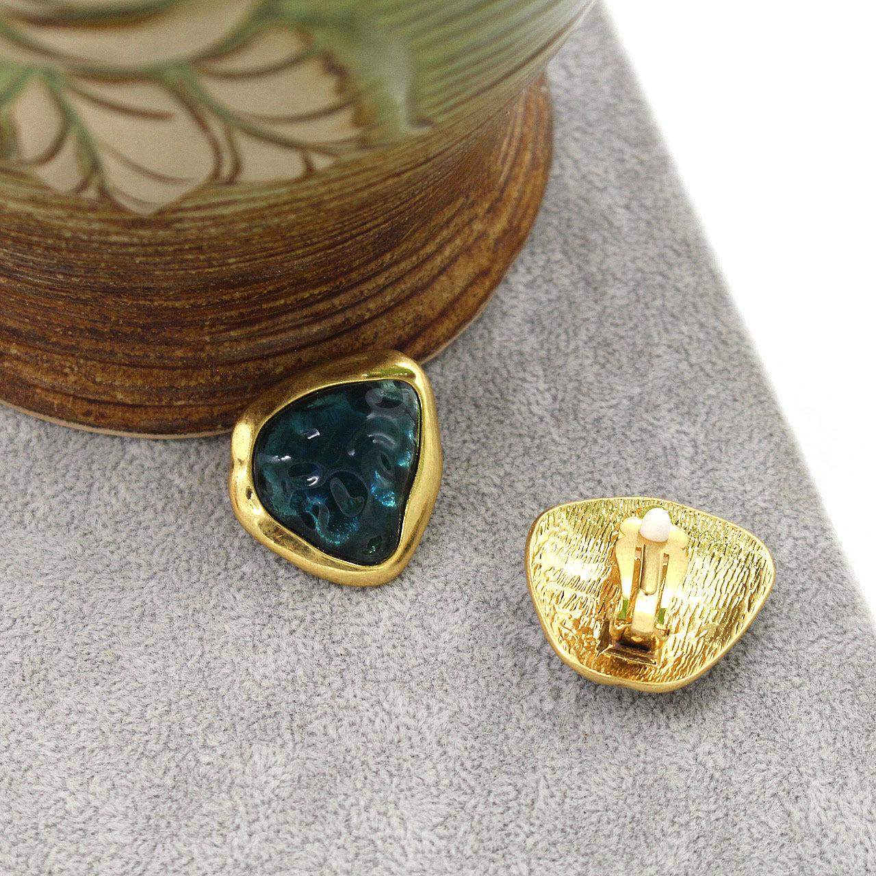 A clip on set of earrings showing the gold-tone back