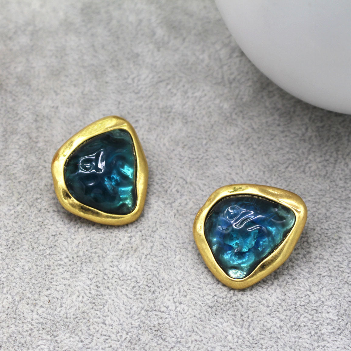 This image shows the earrings against a Grey background. The Centre reminds me of a deep Sea Green /blue