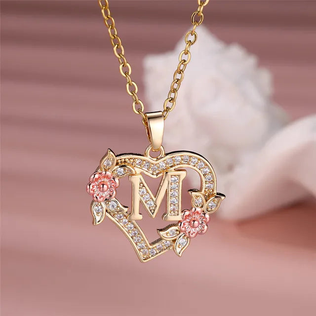 The letter M in a heart pendant necklace with rhinestones