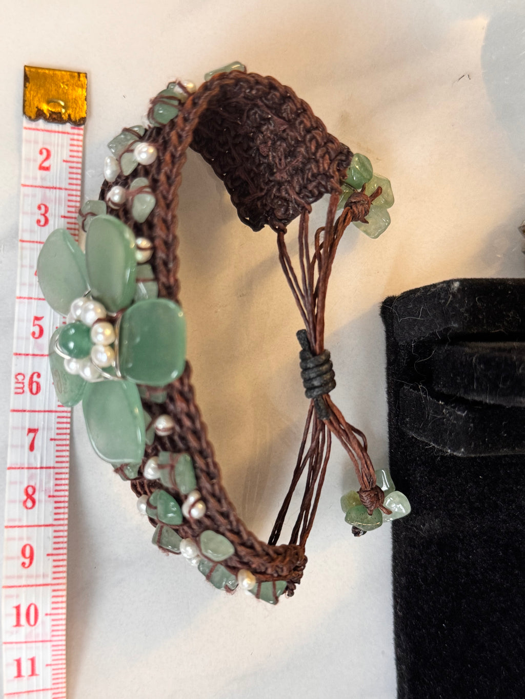 Detail of hand-woven green jade and seed pearl bracelet band. This image displays the measurement of the bracelet which has a slider closure