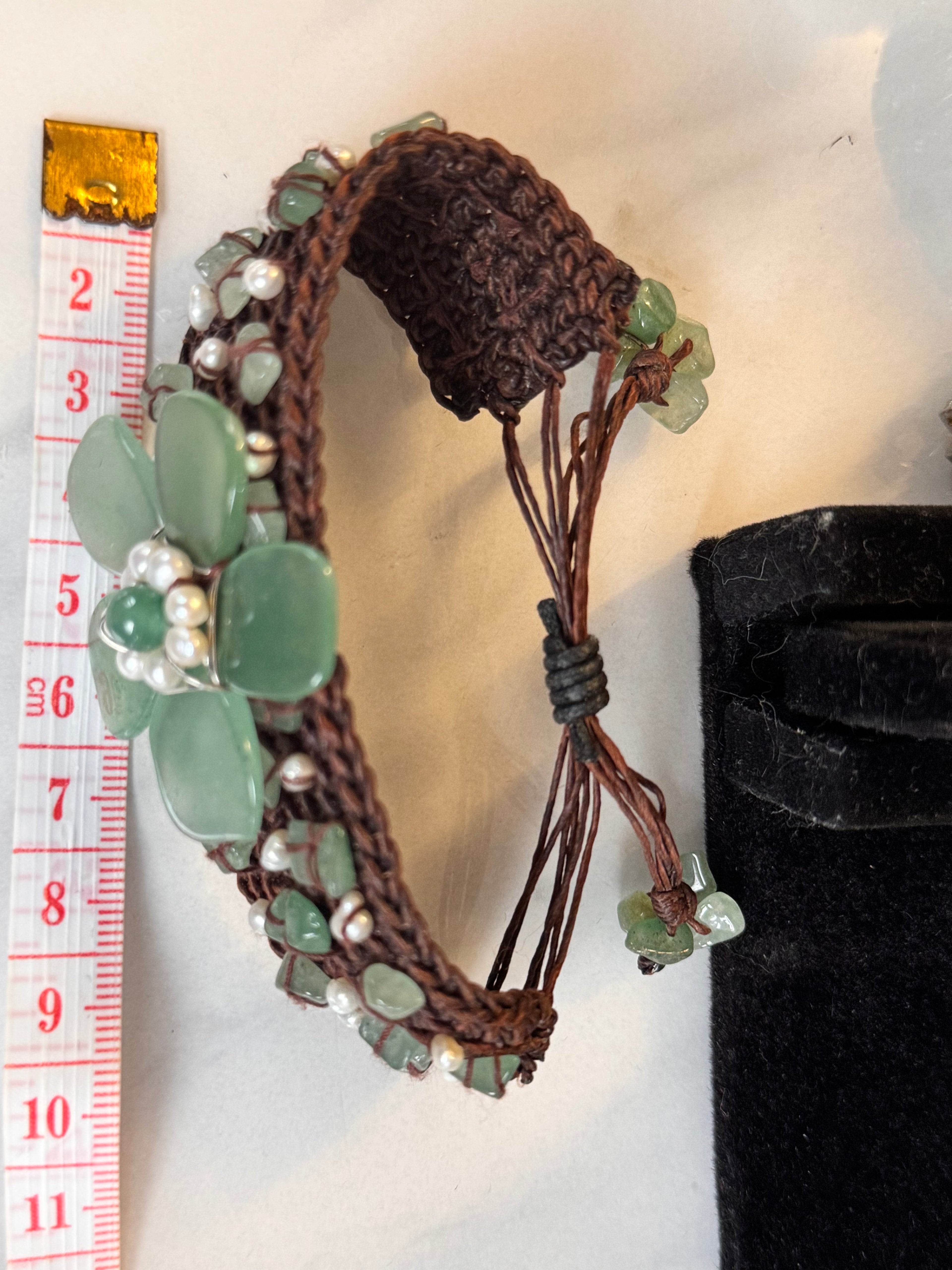 Detail of hand-woven green jade and seed pearl bracelet band. This image displays the measurement of the bracelet which has a slider closure