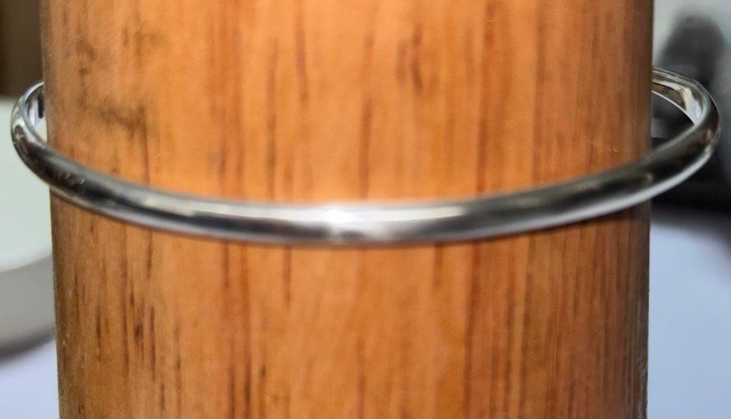 Displaying the reverse of the bangle a very shiny sterling silver Bangle