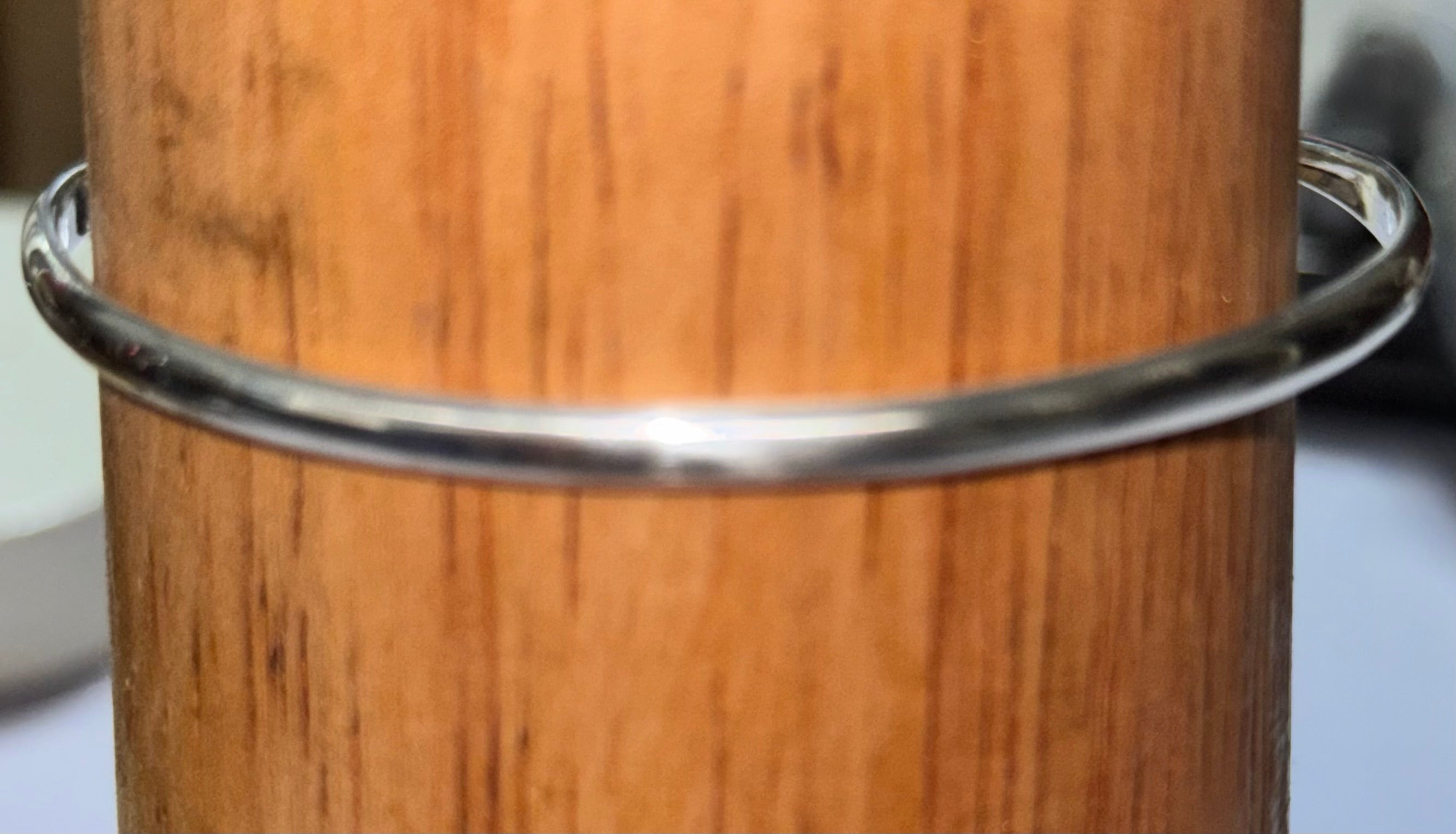 Displaying the reverse of the bangle a very shiny sterling silver Bangle