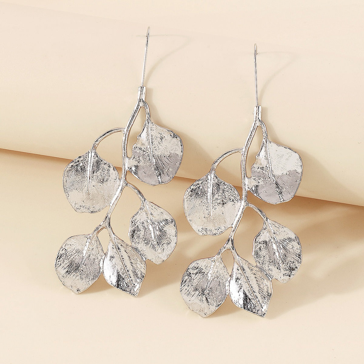 These silver-tone vintage style Leaves on long hook closures with a cream coloured background image