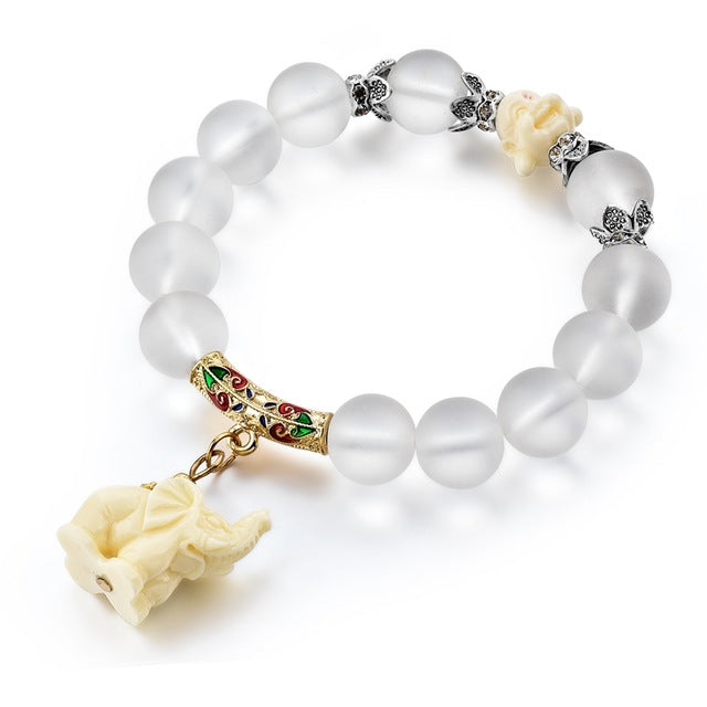 A clear glass beaded bracelet with alloy spacer beads in silver and a gold spacer with an elephant charm