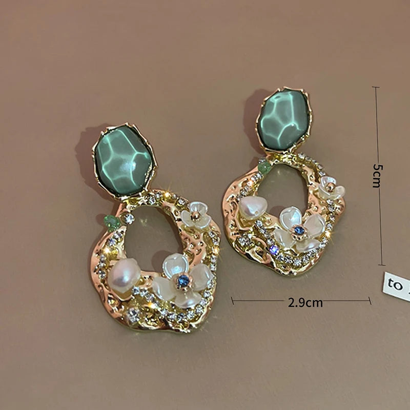 This image details the length of 5cm from the top of the earring to its base and the width of 2.9cm Beautifully displays the CZ's, pearls and flowers on A brown background, possibly card