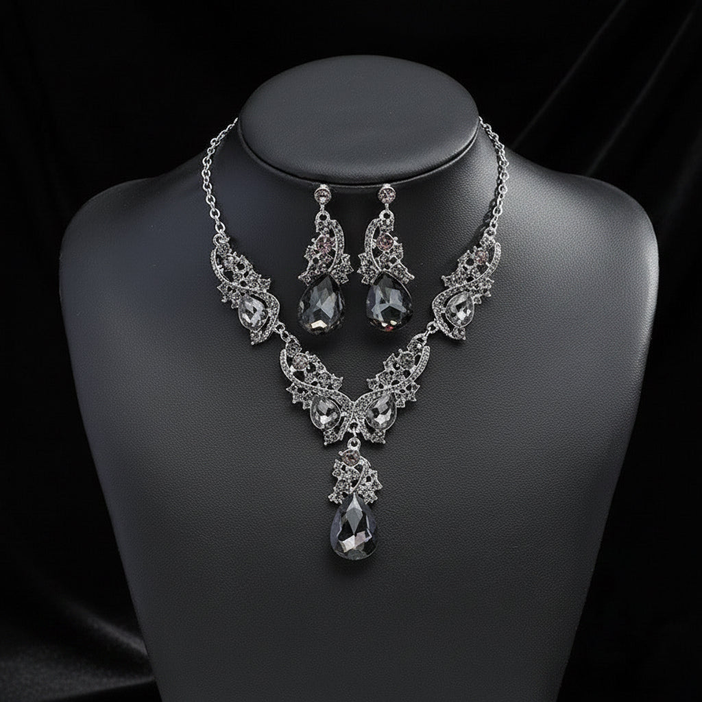 Silver necklace and earrings set on a black mannequin bust with a dark background. This is the unique Grey colour set in silver-tone metal. A gorgeous set in a unique colour