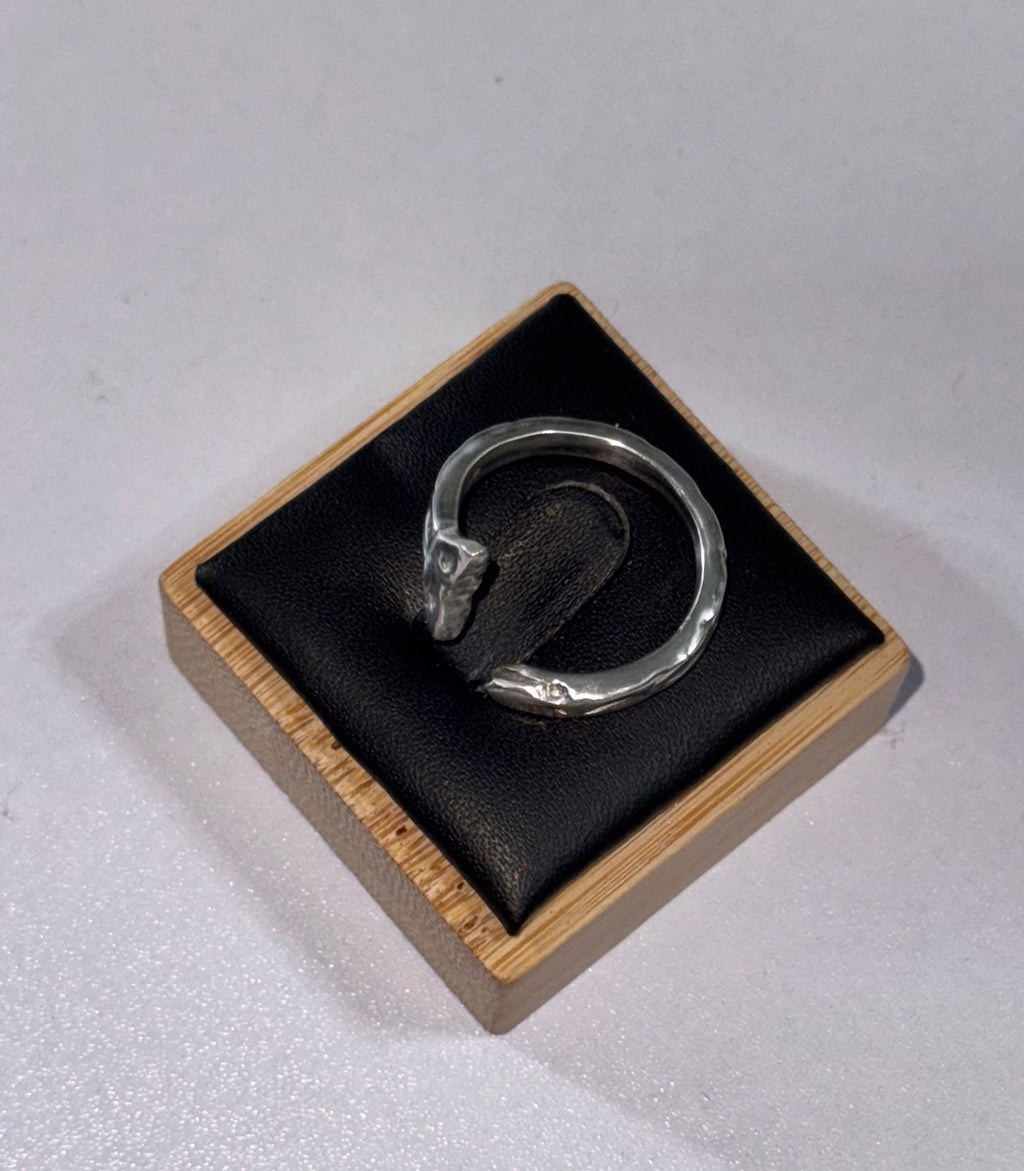 The sterling silver sea snake ring on its side to display the ring from a different angle. its laid on a ring display box.