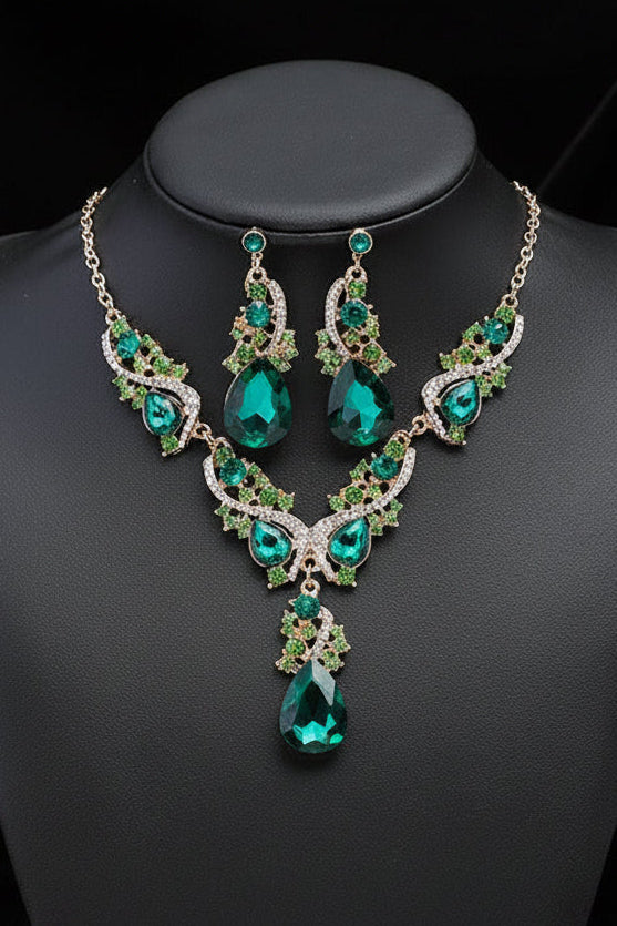 Green & emerald colour gemstone necklace and earrings on a black mannequin bust with a back background
