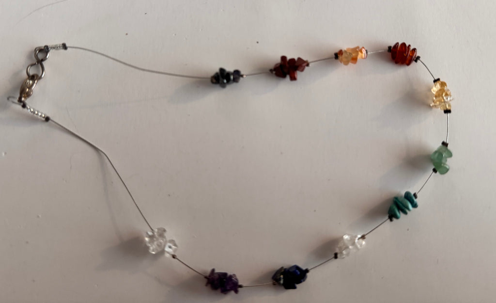 The entire Vintage necklae with it s various stone chips on a white card background