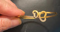 Handmade 24ct gold plated butterfly bangle showing coin knot terminals hooked together to form butterfly shape